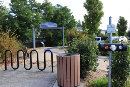 Hard surface trail - bike rack - garbage - dog waste bags - bench with arms - entrance sign - parking lot